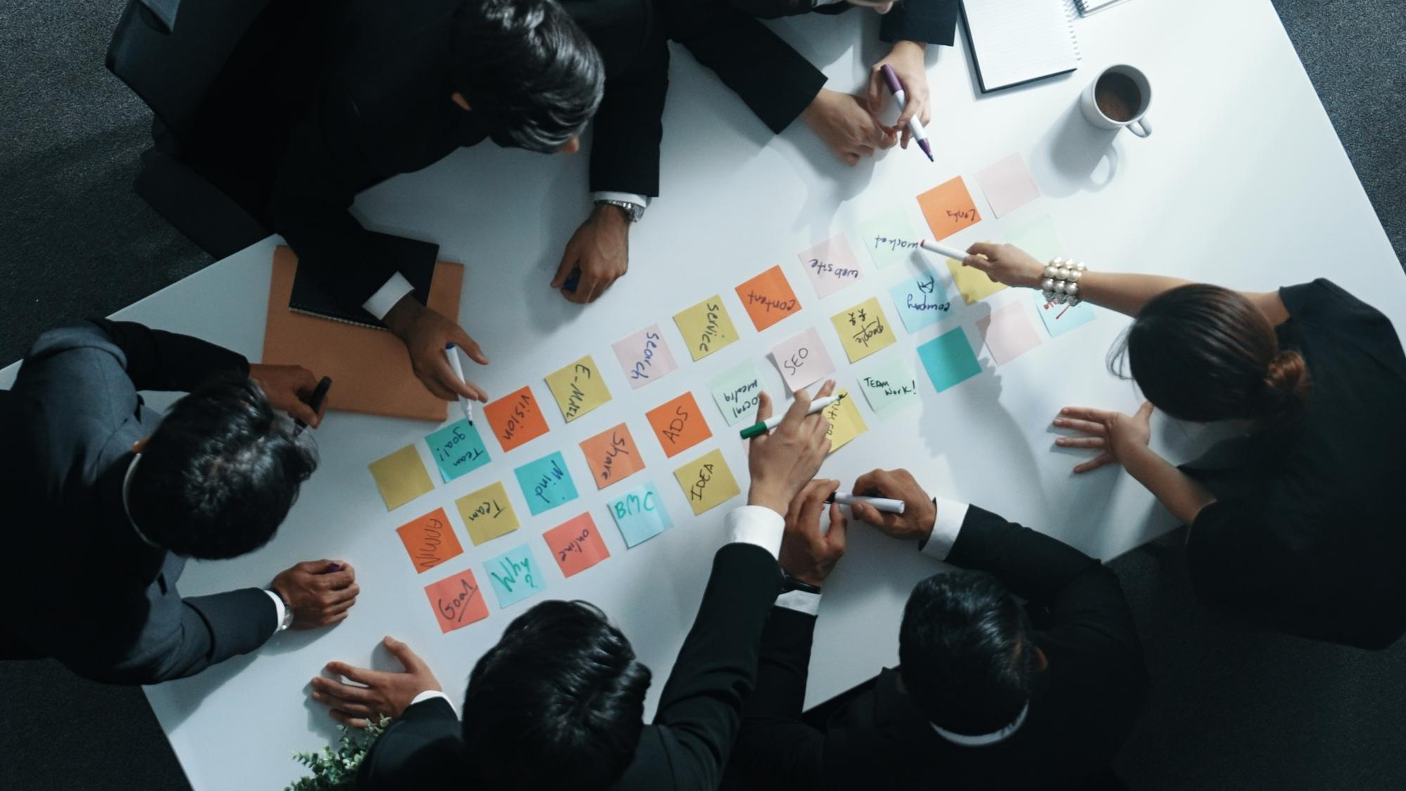 "Marketopia team brainstorming ideas using colorful sticky notes in a meeting"